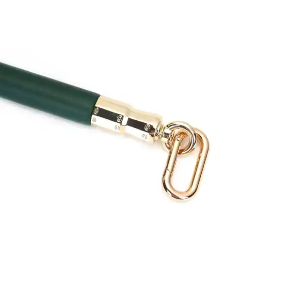 Spreizstange aus grünem Leder und Eukalyptusholz mit vergoldeten Metallbeschlägen. Elegantes BDSM-Accessoire für eine präzise und kontrollierte Fesselung, perfekt für die Mossy Chic-Kollektion.