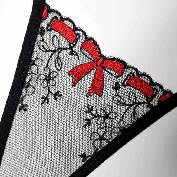 Mini tanga de tul negro bordado con delicadas flores y un lazo rojo central, modelo The Gift de Lucky Cheeks.