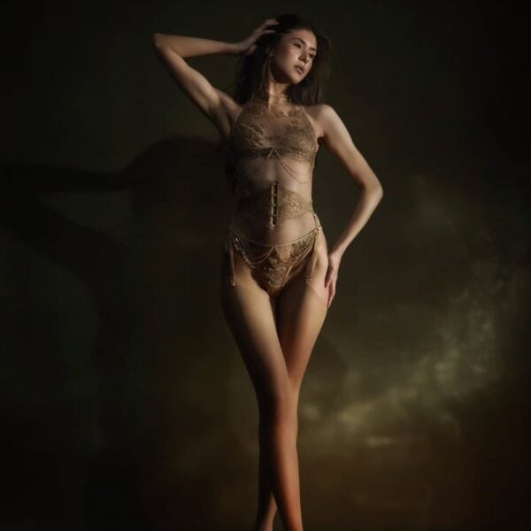 Aimée Korsett Strapsgürtel - CELINE-MARIE bei Brigade Mondaine Paris Aimée Strumpfhalterkorsett der Marke CELINE-MARIE, ausgewählt von Brigade Mondaine Paris, getragen von einem Model in dunklem Studio, das die Struktur des Korsetts, die eingearbeiteten Strumpfhalter und die raffinierten Details hervorhebt.