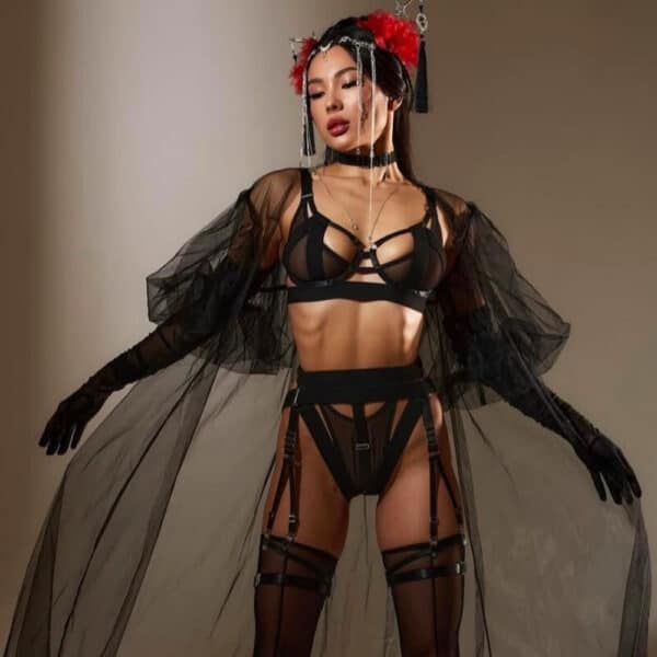 Lingerie Geisha en tulle noir avec découpes franches et bandes élastiques. Culotte ouverte, porte-jarretelles, soutien-gorge et choker assortis. Détails métalliques et ajustements précis. Ligne graphique signée Pivovarova. Fabriqué à la main en Ukraine.