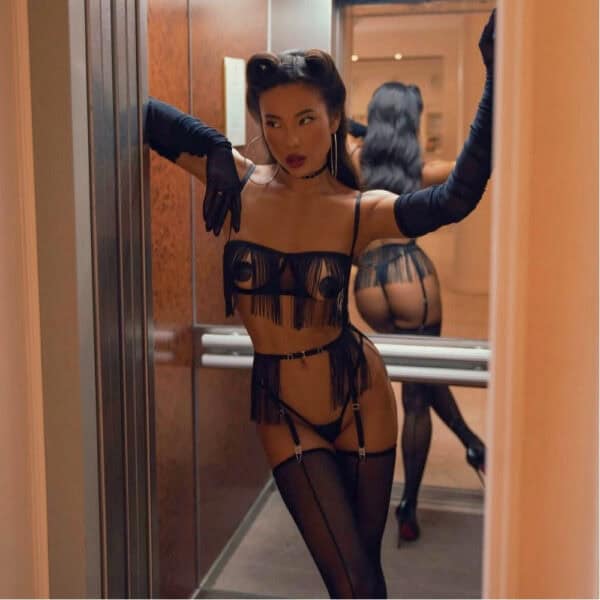 Olivia lingerie in tulle with long bangs and adjustable details. Open bra, micro thong, suspender harness and matching choker. Minimalist, dynamic styling by Pivovarova. Fluid, graphic silhouette. Hand-crafted pieces.