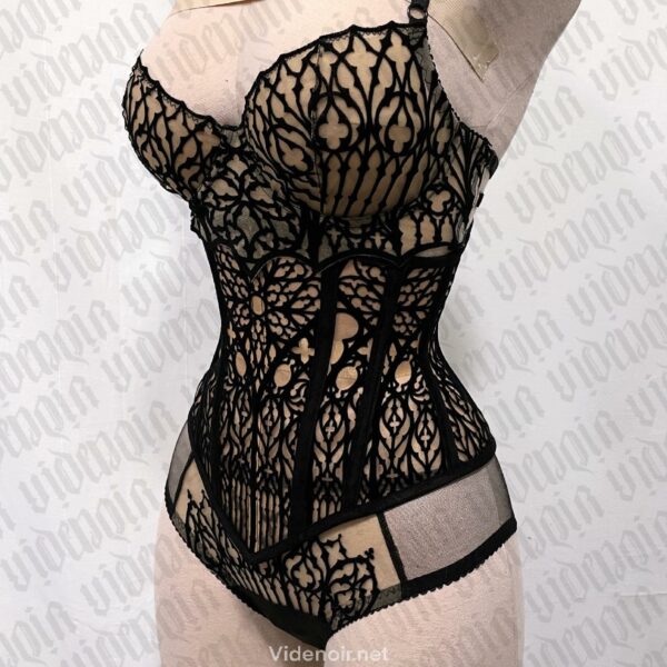 VIDE NOIR - Corset Cathédrale Effet Tatouage Corset underbust gothique en tulle nude orné de velours noir, avec baleines acier et doublure en velours. Inspiré des formes gothiques. Silhouette structurée et confort assurés.
