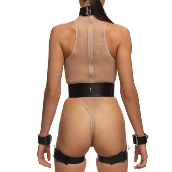 Full Set REVNA signé Anoeses : ensemble bondage en cuir noir avec harnais, collier, ceinture et menottes de cuisse reliées par des sangles – silhouette graphique et fétiche au style affirmé.