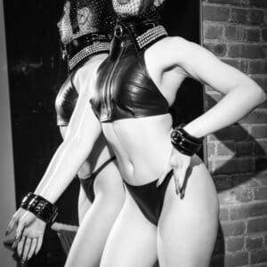 La modelo lleva el collar HOUSE OF SXN Bondage Serpens de cuero negro con cadena de metal, selección Brigade Mondaine Paris