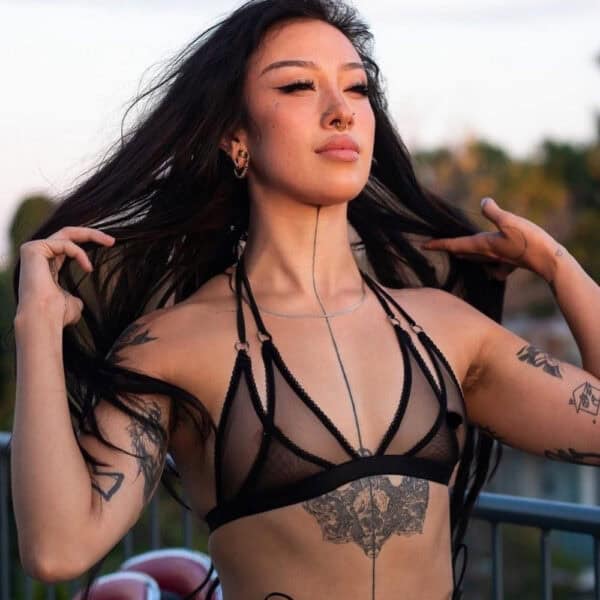 Dessous aus schwarzem, doppellagigem Tüll, der hinter dem Nacken mit einem Spaghetti-Gummiband gebunden wird. Silberne Metallringe für einen verspielten und eleganten Touch.