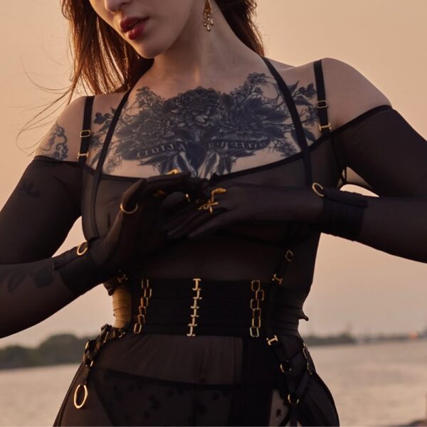 Harnais corset FLASH en tulle noir et sangles croisées avec anneaux dorés, porté sur le buste, vue rapprochée des détails et de la structure centrale - Brigade Mondaine Paris