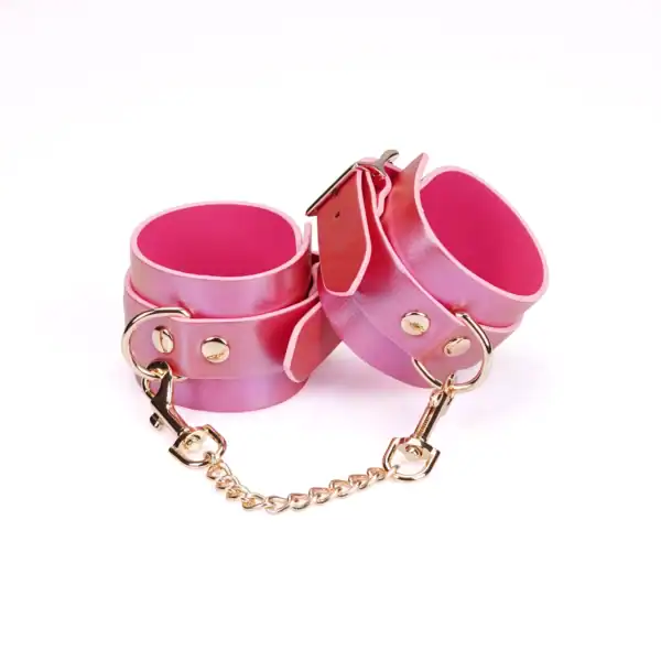 Fußfesseln Lustre Rosa LIEBE SEELE aus rosafarbenem, irisierendem Leder mit rosafarbenem Innenfutter, Nieten und goldener Metallkette, präsentiert auf weißem Hintergrund