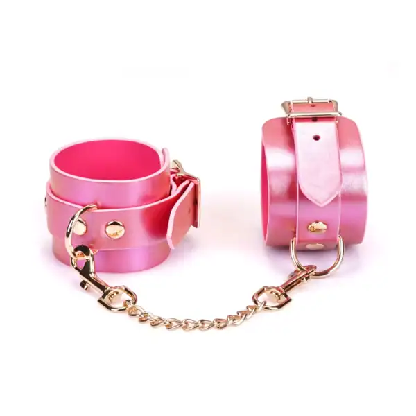 Fußfesseln Lustre Rosa LIEBE SEELE aus rosafarbenem, irisierendem Leder mit rosafarbenem Innenfutter, Nieten und goldener Metallkette, präsentiert auf weißem Hintergrund