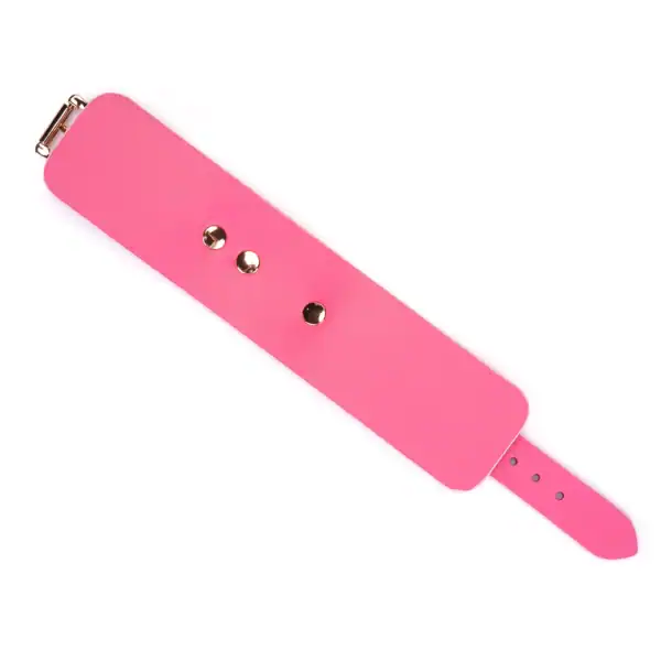 Handschellen Lustre Rosa LIEBE SEELE aus rosafarbenem Glattleder mit goldenen Metallnieten und verstellbarem Riemen, präsentiert auf weißem Hintergrund