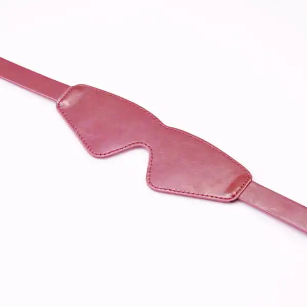 LIEBE SEELE Lustre Rosa Маска из блестящей розовой кожи с охватывающей формой, регулируемым ремешком и тщательной отделкой, представленная на белом фоне в виде товара.