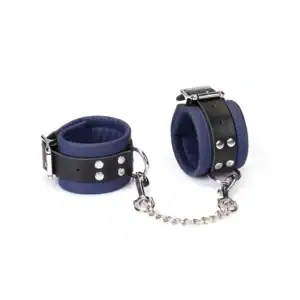 Наручники LIEBE SEELE Cerulean из синей кожи с мягкой внутренней отделкой, регулируемой застежкой, металлическими кольцами и серебристой цепочкой, сфотографированные на белом фоне.