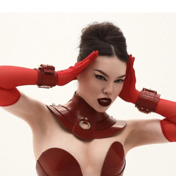RE:STRICT - DAELOS Leather Corset - RE:STRICT - MAGNUS Leather Handcuffs Red leather handcuffs with gold D-ring and red leather corset with metallic finish, RE:STRICT bondage creations by craftsmen