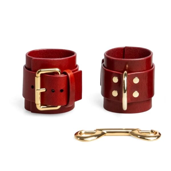 RE:STRICT - Menottes Cuir MAGNUS Menottes en cuir rouge ajustables avec D-ring et lien métallique doré création bondage minimaliste et artisanale signée RE:STRICT