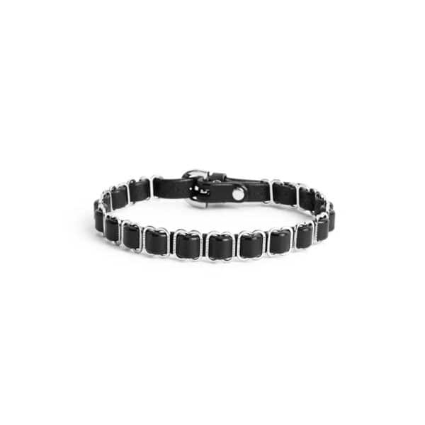 Black ANOESES choker worn around the neck of a female model, featuring aligned metal rings and an adjustable structure, high-end fetish aesthetic Brigade Mondaine Paris.