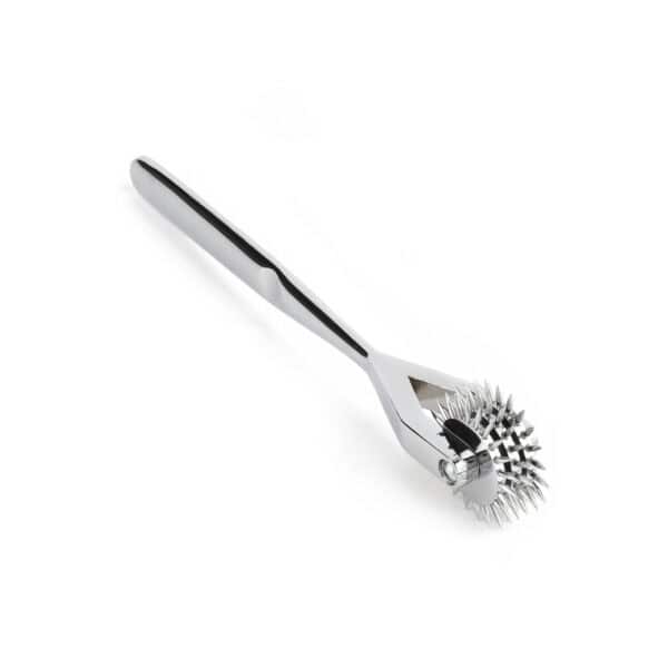 Ролик Wartenberg из блестящей нержавеющей стали с зубчатыми колесами, медицинский дизайн в новом свете, представленный Brigade Mondaine Paris на светлом фоне.