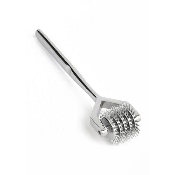 Ролик Wartenberg из блестящей нержавеющей стали с зубчатыми колесами, медицинский дизайн в новом свете, представленный Brigade Mondaine Paris на светлом фоне.