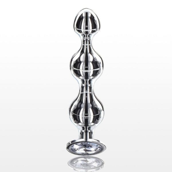 Analplug in poliertem Metall mit transparentem, facettiertem Kristall, ausladender Basis und glänzendem Finish, präsentiert von Brigade Mondaine Paris.