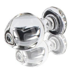 Plug anal en verre transparent poli à finition brillante, forme sphérique avec base évasée, présenté sur fond blanc, sélection Brigade Mondaine Paris.