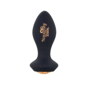 Schwarzer Analplug aus Silikon mit einer Basis, die mit einem facettierten bernsteinfarbenen Schmuckstück verziert ist, in der Hand gehalten, angeboten von Brigade Mondaine Paris.