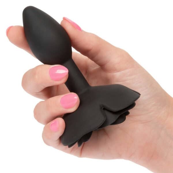 Plug anal noir en silicone mat, tête sculptée en forme de rose avec base évasée, présenté par Brigade Mondaine Paris.