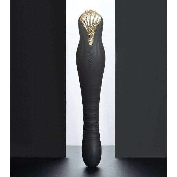 Schwarzer Stimulator aus strukturiertem Silikon mit goldenem Finish, vertikal auf dunklem Hintergrund dargestellt, angeboten von Brigade Mondaine Paris.