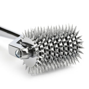 Roulette de Wartenberg en acier inoxydable brillant avec roulettes dentelées, design médical revisité, présentée par Brigade Mondaine Paris sur fond clair.