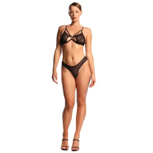 ANOESES Set aus schwarzem Tüll, bestehend aus einem BH mit grafischen Riemen und einem passenden Tanga, getragen von einem stehenden weiblichen Modell. Strukturierte Linien und kontrollierte Transparenz, hochwertige Fetisch-Ästhetik Brigade Mondaine Paris.