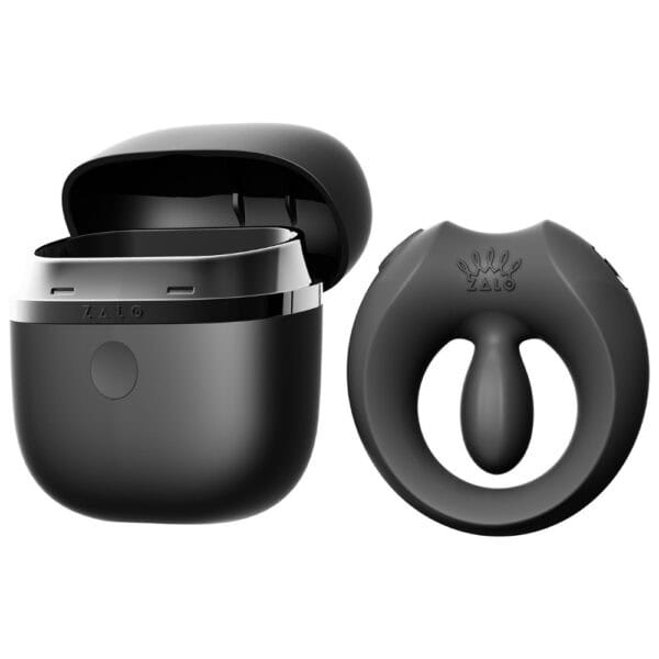 APIS connected cockring presented with its charging case, USB cable and warranty card, set against a light background in a minimalist, elegant setting.