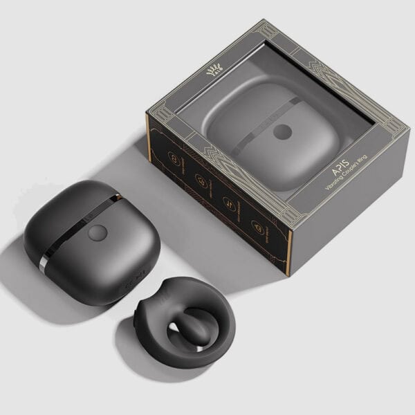 APIS connected cockring presented with its charging case, USB cable and warranty card, set against a light background in a minimalist, elegant setting.