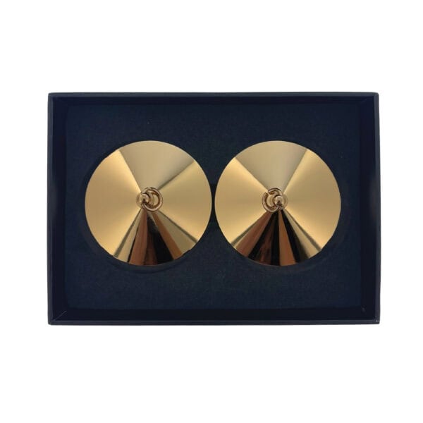 Nippelhalter mit goldenen Ringen Luxus-Design | Brigade Mondaine Ein Paar vergoldeter Übertöpfe aus Metall mit glatter, kreisförmiger Oberfläche, jeweils mit einem kleinen Ring in der Mitte. Sie werden auf weißem Hintergrund in einer minimalistischen, eleganten Ästhetik präsentiert.