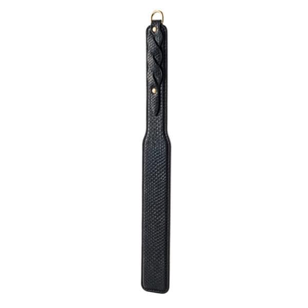 Model trägt einen transparenten schwarzen Body und hält ein BDSM-Paddle aus schwarzem Leder mit strukturiertem Finish. Fotografiert vor einem weißen Hintergrund in einer schlichten und eleganten Inszenierung.