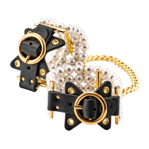 Tobilleras de cuero negro adornadas con perlas y unidas por una cadena dorada, llevadas por la modelo, ofrecidas por Brigade Mondaine Paris.
