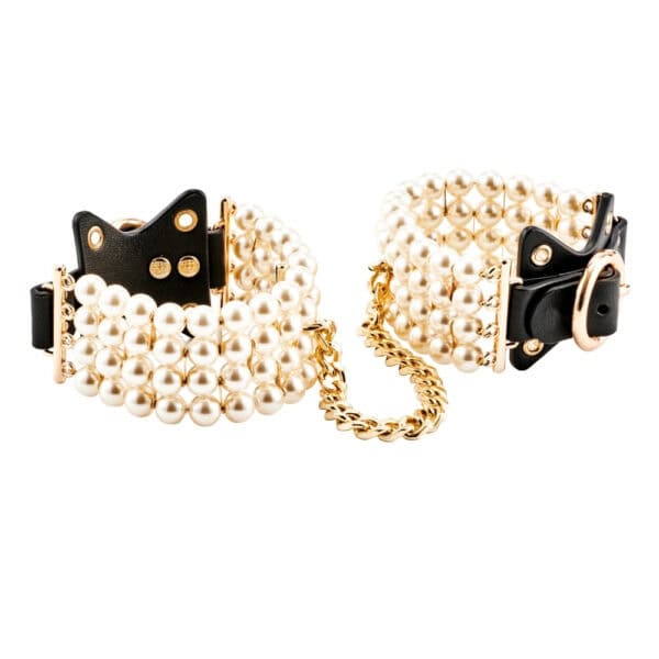 Tobilleras de cuero negro adornadas con perlas y unidas por una cadena dorada, llevadas por la modelo, ofrecidas por Brigade Mondaine Paris.