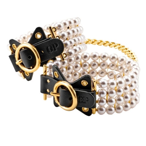 Tobilleras de cuero negro adornadas con perlas y unidas por una cadena dorada, llevadas por la modelo, ofrecidas por Brigade Mondaine Paris.