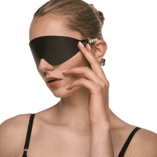 BDSM-Maske aus schwarzem Leder mit perlenbesetzten Rändern und goldenen Beschlägen, ein hochwertiges Accessoire zur visuellen Deprivation, ausgewählt von Brigade Mondaine Paris.