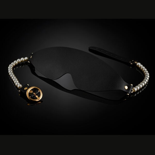 BDSM-Maske aus schwarzem Leder mit perlenbesetzten Rändern und goldenen Beschlägen, ein hochwertiges Accessoire zur visuellen Deprivation, ausgewählt von Brigade Mondaine Paris.