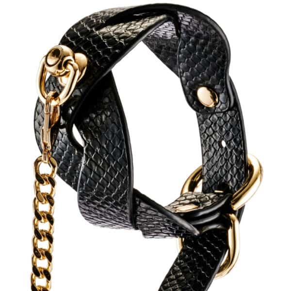 Model wearing a textured black BDSM necklace with gold chain and matching lanyard, restraint accessory offered by Brigade Mondaine Paris.