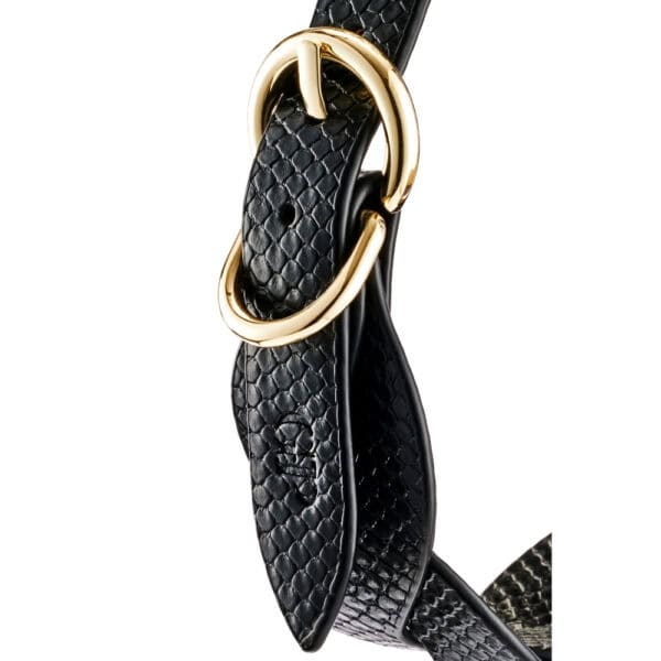 Model wearing a textured black BDSM necklace with gold chain and matching lanyard, restraint accessory offered by Brigade Mondaine Paris.