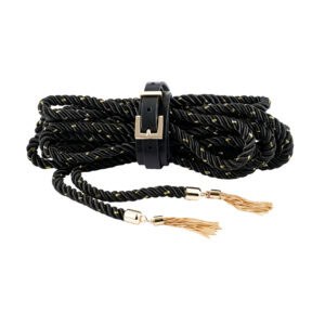 Schwarzes, gedrehtes BDSM-Seil mit goldenen Einlagen, das mit einem Lederriemen und einer Metallschnalle geschlossen wird, mit goldenen Verzierungen und Pompons versehen ist und auf schwarzem Hintergrund präsentiert wird.
