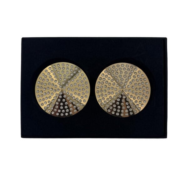 Paire de cache-tétons dorés circulaires ornés de strass brillants, présentés dans un écrin noir sur fond blanc, avec une esthétique élégante et minimaliste.