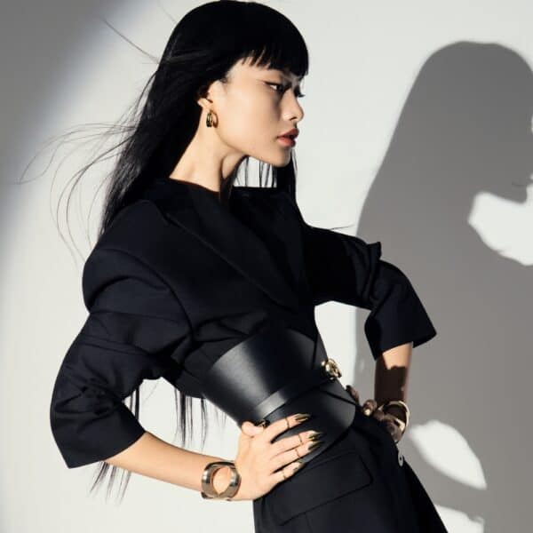 Corset ceinture HUDIA IINFYNII en cuir noir avec fermoir métallique infini porté sur un tailleur noir, accessoire structurant et graphique proposé par Brigade Mondaine Paris