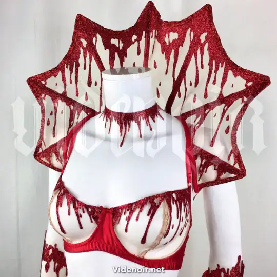 Col Gouttes de Sang VIDE NOIR Brigade Mondaine Paris couture Col Gouttes de Sang VIDE NOIR présenté chez Brigade Mondaine Paris, col rigide rouge pailleté aux motifs de gouttes stylisées, porté sur buste avec finition graphique et sculpturale.