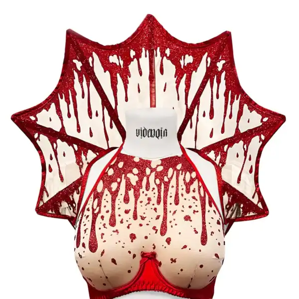Col Gouttes de Sang VIDE NOIR Brigade Mondaine Paris couture Col Gouttes de Sang VIDE NOIR présenté chez Brigade Mondaine Paris, col rigide rouge pailleté aux motifs de gouttes stylisées, porté sur buste avec finition graphique et sculpturale.