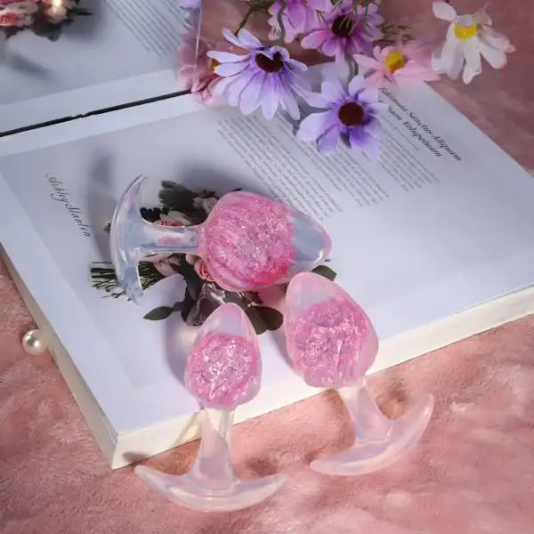 LIEBE SEELE pink silicone plug with spiral surface and transparent flared base, hand-held on white background, detailed product view