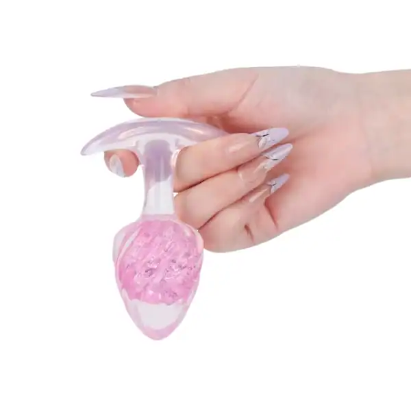 LIEBE SEELE pink silicone plug with spiral surface and transparent flared base, hand-held on white background, detailed product view