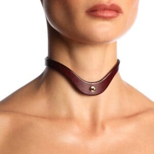 Collier ras-de-cou en cuir bordeaux ANOESES avec bouton métallique central, porté sur le cou d’un mannequin, vue rapprochée sur fond blanc.