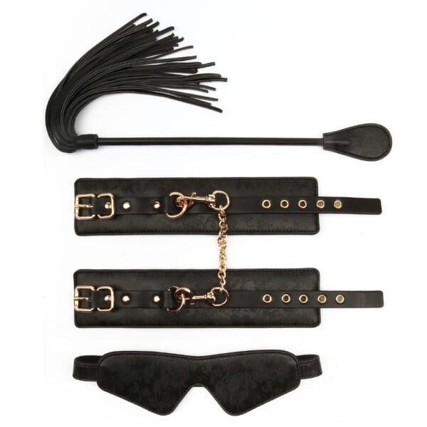 BDSM-Set aus schwarzem Leder, bestehend aus einem Paar Handschellen, die mit einer goldenen Kette verbunden sind, einer Verdunkelungsmaske und einer passenden Reitgerte, präsentiert auf weißem Hintergrund in einer eleganten Inszenierung.