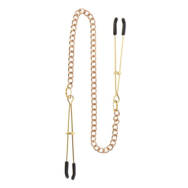 Model wearing gold-plated metal nipple clamps connected by a thin chain, photographed against a solid colored background with the framing centered on the bust.
