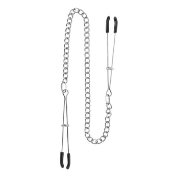Modell trägt Nippelklemmen aus Metall, die mit einer dünnen Kette verbunden sind. Fotografiert vor einem einfarbigen Hintergrund mit einem auf die Büste zentrierten Bildausschnitt.