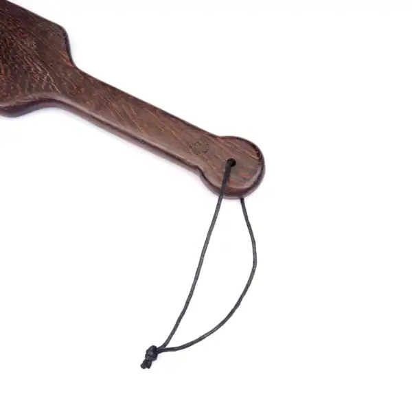 Paddle en bois wengé de la marque Liebe Seele, à la finition lisse avec dragonne de maintien, présenté sur fond clair dans l’univers Brigade Mondaine Paris.